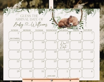 May include: A white baby shower calendar on a wooden easel. The calendar has a bear illustration and text that reads "Guess the Arrival Date of Baby Williams." The calendar grid is for December and January.
