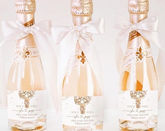 Puede incluir: Tres mini botellas de champán con lazos de satén blanco y etiquetas personalizadas que dicen "Pop it when she pops, enjoy a toast when baby Williams arrives!"