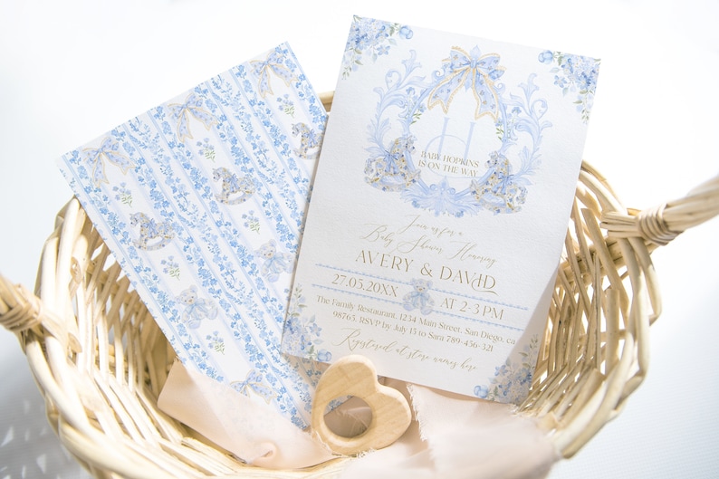 Op de afbeelding: Een blauwe en gouden babyborrel uitnodiging met een bloemenontwerp en een schommelpaard. De uitnodiging luidt "Baby Shower Honoring Avery & David 27.05.20XX van 14:00-15:00 uur The Family Restaurant, 1234 Main Street, San Diego, CA 98765. RSVP v&oacute;&oacute;r 15 mei naar 789-45-320.  RSVP en winkelnamen hier."