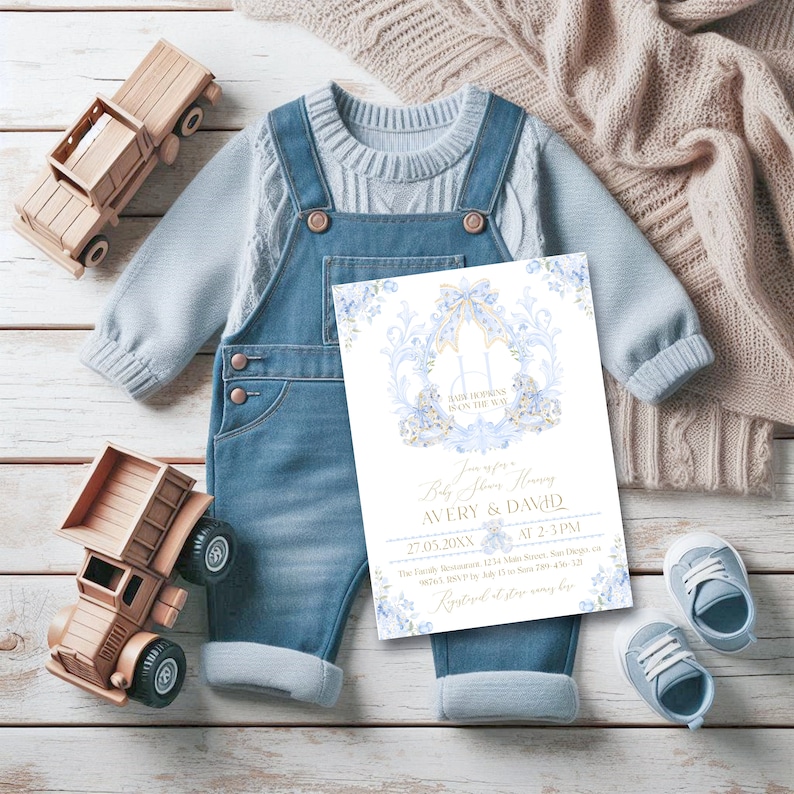 Op de afbeelding: Een blauwe en gouden babyborrel uitnodiging met een koets ontwerp en de tekst "Baby Shower Honoring Avery & David 27.05.20XX van 14:00-15:00 uur The Family Restaurant 1234 Main Street, San Diego, CA 00012 RSVP voor 15 juli 200-456-7890  Registered at store name"