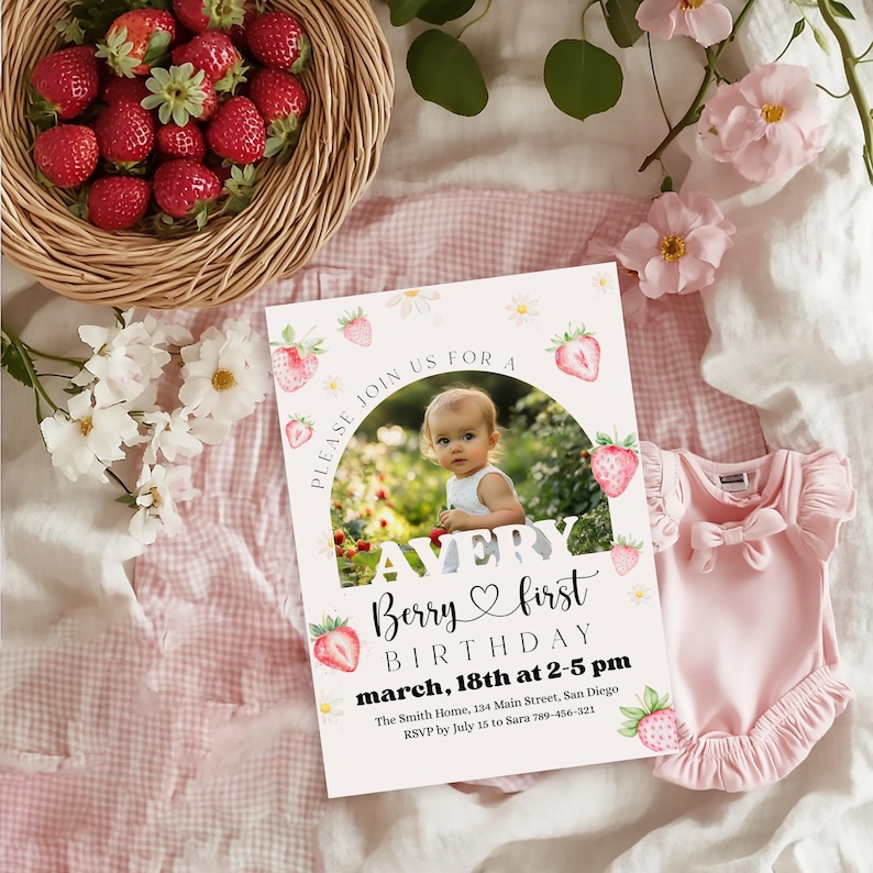 May include: A baby's first birthday invitation with a photo, strawberries, and daisies. The invitation reads "Avery Berry first birthday march, 18th at 2-5 pm". A pink onesie and a basket of strawberries are also in the image.
