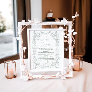 May include: A white framed sign with a green floral design and the text "Late Night Diapers" in a decorative font. The sign includes a poem about late-night diaper changes and encourages guests to write a note for the new parents.