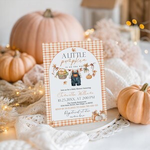 Puede incluir: Una invitaci&oacute;n a un baby shower con tem&aacute;tica oto&ntilde;al. La invitaci&oacute;n presenta el texto "A Little Pumpkin is on the Way" e incluye los detalles del evento. El dise&ntilde;o incorpora calabazas, follaje oto&ntilde;al y un patr&oacute;n de cuadros. Varias calabazas de diferentes tama&ntilde;os est&aacute;n en el fondo.