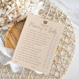 May include: A pink and blue printable game card with the text "Guess who said it Mommy or Daddy" and a list of 14 statements about pregnancy and babies.  Each statement has a pink or blue heart next to it for players to mark their guesses.