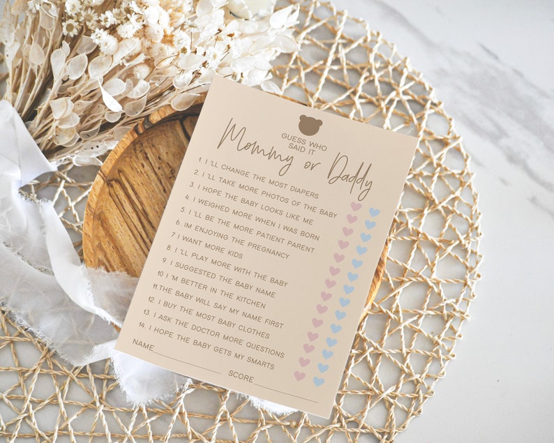 May include: A pink and blue printable game card with the text "Guess who said it Mommy or Daddy" and a list of 14 statements about pregnancy and babies.  Each statement has a pink or blue heart next to it for players to mark their guesses.