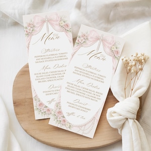 Peut inclure: Deux cartes de menu élégantes avec un nœud rose et un motif floral. Le menu comprend des entrées, des plats principaux et des options de dessert. Les cartes sont sur une surface en bois avec une serviette blanche et des fleurs séchées.