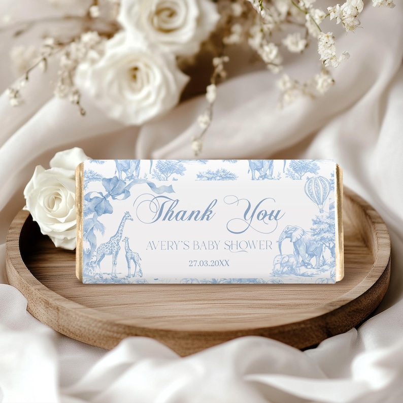 May include: Blue and white thank you favor box with a giraffe, elephant, and hot air balloon design. The text reads "Thank You Avery's Baby Shower 27.03.20XX".