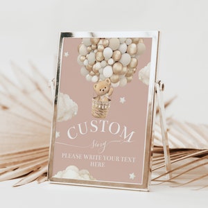 Pode incluir: Um sinal imprimível com fundo rosa que apresenta um urso de peluche num balão de ar quente feito de balões dourados e brancos. O sinal diz "CUSTOM sign PLEASE WRITE YOUR TEXT HERE".