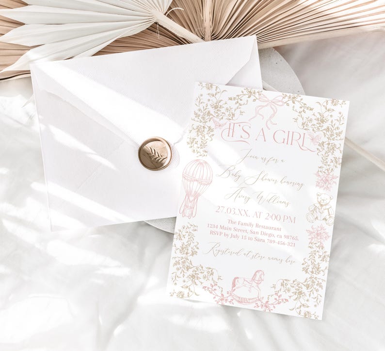 Op de afbeelding: Een uitnodiging voor een babyshower met de tekst "IT'S A GIRL" in een sierlijk handschrift. De uitnodiging heeft een roze en gouden bloemenontwerp, een illustratie van een luchtballon en een schommelpaard. Een envelop met een gouden zegel is ook aanwezig.