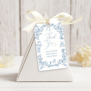 May include: A white thank you tag with blue floral border and illustrations of a hot air balloon, teddy bear, and rocking horse. The text reads "Thank You Avery & David Baby Shower March 20XX".