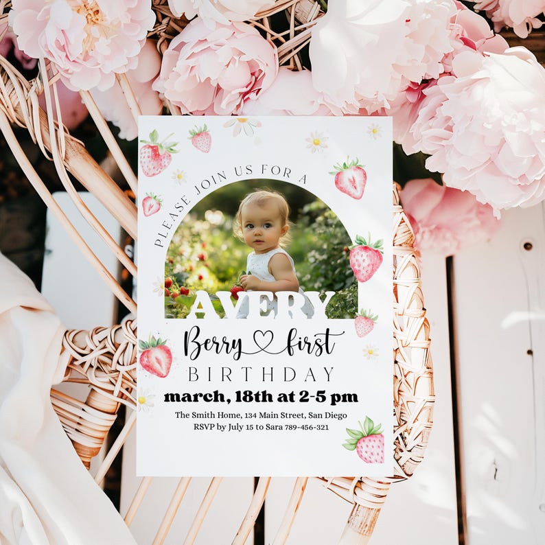 May include: A baby's first birthday invitation featuring a photo of a baby, strawberries, and daisies. The invitation reads "Avery Berry first birthday" with the date and time. The invitation is surrounded by pink flowers.