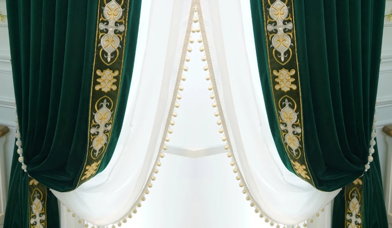 May include: Dark green velvet curtains with gold and cream embroidered borders. Sheer white curtains with cream pom-pom trim are layered behind the velvet drapes, creating a luxurious window dressing.
