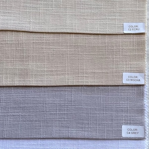Può includere: Campioni di tessuto in vari colori neutri: bianco sporco, écru, moka, grigio, bianco e burro. Ogni campione presenta una trama strutturata e un'etichetta colore.