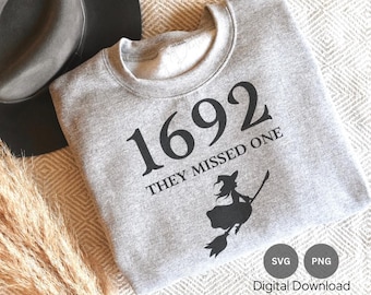 May include: Gray sweatshirt with the text "1692 They Missed One" and a black silhouette of a witch riding a broomstick.