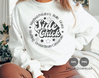 May include: White sweatshirt with a black graphic design that says "Side Chick" surrounded by a circle of text that reads "Mashed Potato's Rolls Gravy Stuffing Green Bean Casserole".