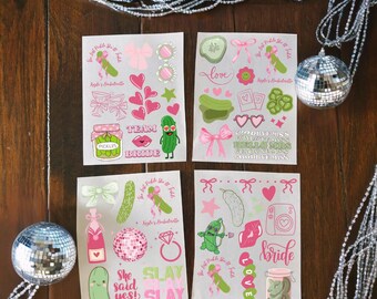 May include: Four sheets of stickers with a pickle theme, featuring pink and green designs. The stickers include hearts, bows, pickles, and text like "Bride", "Slay", and "She said yes!". Decorative disco balls and silver garland are in the background.