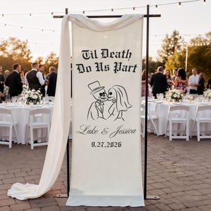 May include: A cream-colored wedding banner with the text "Til Death Do Us Part" and a skeleton couple illustration. The banner also includes the names "Luke & Jessica" and the date "9.27.2026". The banner is draped with a white fabric.