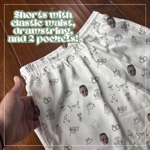 May include: White shorts with an elastic waistband, drawstring, and two pockets. The shorts are decorated with a pattern of wedding-themed line drawings and faces. The text "Shorts with elastic waist, drawstring, and 2 pockets!" is at the top.
