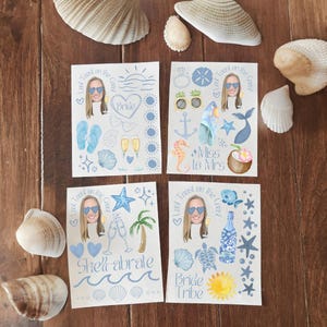 May include: Four sheets of paper with a blue and white watercolor design featuring a bride-to-be's face and various beach-themed illustrations. The text on the sheets reads "Last Toast on the Coast", "Bride", "Miss to Mrs", "Shell-abrate", and "Bride Tribe".