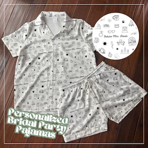 May include: White personalized bridal party pajamas set. The set includes a button-down shirt and shorts, both covered in a black line art pattern of camping-themed icons and the text "Future Mrs. Devin". The words "Personalized Bridal Party Pajamas" are also visible.