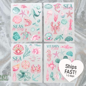 May include: Four sheets of watercolor-style stickers featuring marine life in pink and teal tones. Illustrations include a whale, sea turtle, lobster, octopus, seahorse, shells, and coral. Text includes "SEAS the Day", "SEA Living", "SEA Life", and "VITAMIN Sea".