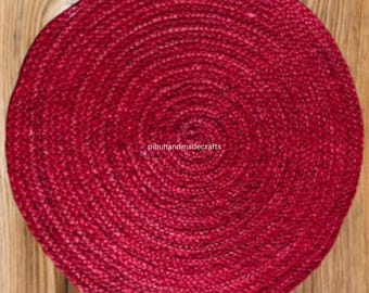 Könnte beinhalten: Ein runder, roter Jute-Platzteller mit gewebtem Muster. Der Platzteller ist aus Naturfasern gefertigt und hat einen rustikalen Look.