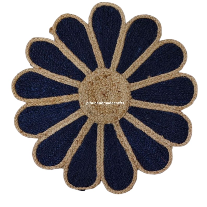 K&ouml;nnte beinhalten: Ein runder Jute-Teppich mit Blumenmuster. Der Teppich hat eine dunkelblaue Mitte mit einem hellbraunen Rand. Der Teppich ist aus Naturfasern gefertigt und hat einen rustikalen Look.