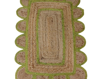 May include: A rectangular jute rug with a scalloped edge. The rug features a natural brown color with a green border and scalloped trim. The rug's dimensions are approximately 36 inches by 60 inches.