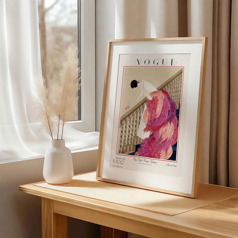 Digital Download Of A November 1 1924 Vogue Cover By George Wolfe Plank Showing An Art Deco Woman In A White Winter Gown Leaning Over A Staircase Toward A Pink Rose With Dramatic Pink Feathered Train. Printable Vintage Wall Decor For Cottagecore Farmhouse Glam Gallery Walls Fashion History Lovers And Gift Buyers.