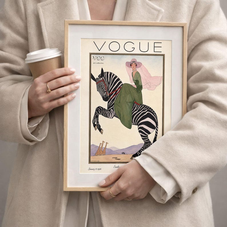 Digitally restored 1926 Vogue magazine cover titled Southern Fashions Number, featuring a stylish woman in a flowing green dress and pink hat riding a zebra in a desert landscape with giraffes and mountains. Vintage Art Deco fashion illustration digital download ideal for gallery walls, eclectic decor, and gifts for fashion history and vintage art lovers.