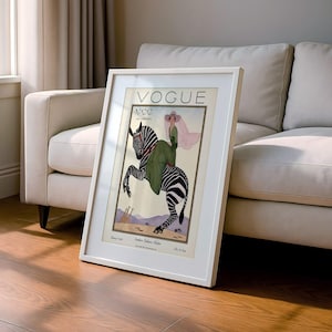 Digitally restored 1926 Vogue magazine cover titled Southern Fashions Number, featuring a stylish woman in a flowing green dress and pink hat riding a zebra in a desert landscape with giraffes and mountains. Vintage Art Deco fashion illustration digital download ideal for gallery walls, eclectic decor, and gifts for fashion history and vintage art lovers.