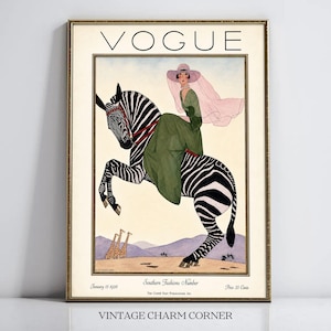 May include: A framed vintage Vogue magazine cover print from January 15, 1926, titled Southern Fashions Number. It features an illustration of a person in a green dress and pink veil riding a zebra, with two giraffes in the background landscape.