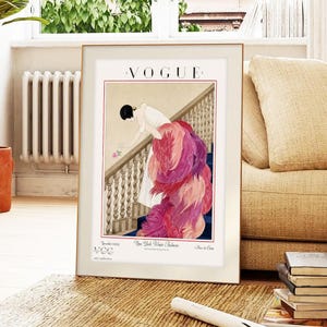 Digital Download Of A November 1 1924 Vogue Cover By George Wolfe Plank Showing An Art Deco Woman In A White Winter Gown Leaning Over A Staircase Toward A Pink Rose With Dramatic Pink Feathered Train. Printable Vintage Wall Decor For Cottagecore Farmhouse Glam Gallery Walls Fashion History Lovers And Gift Buyers.