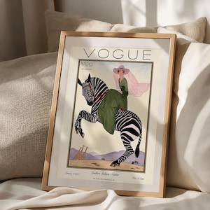 Digitally restored 1926 Vogue magazine cover titled Southern Fashions Number, featuring a stylish woman in a flowing green dress and pink hat riding a zebra in a desert landscape with giraffes and mountains. Vintage Art Deco fashion illustration digital download ideal for gallery walls, eclectic decor, and gifts for fashion history and vintage art lovers.