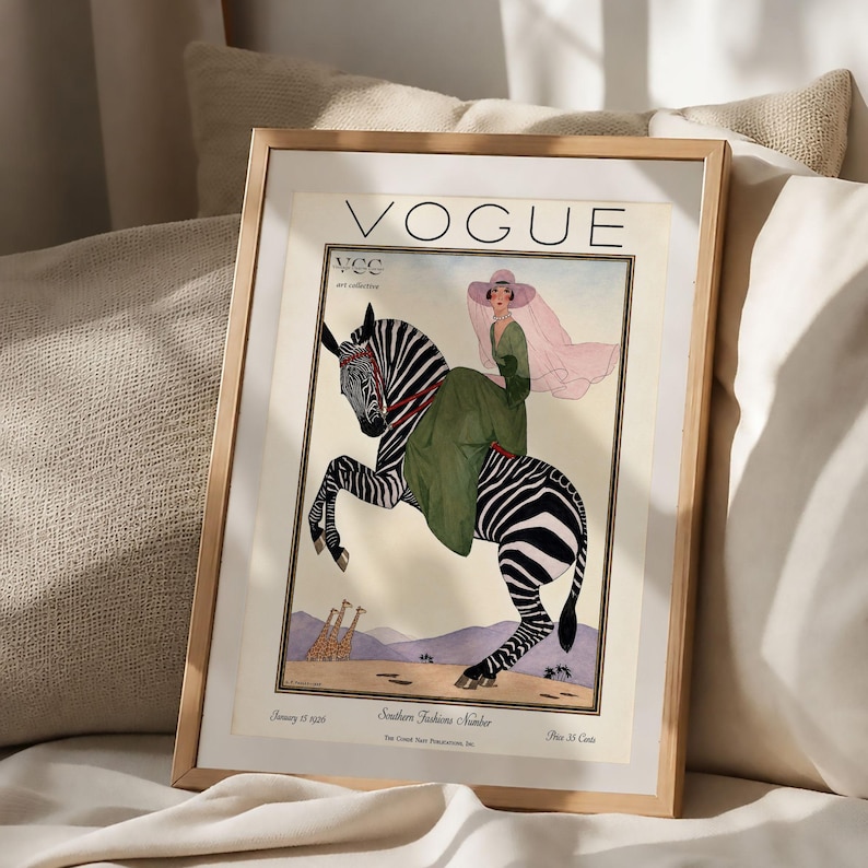 Digitally restored 1926 Vogue magazine cover titled Southern Fashions Number, featuring a stylish woman in a flowing green dress and pink hat riding a zebra in a desert landscape with giraffes and mountains. Vintage Art Deco fashion illustration digital download ideal for gallery walls, eclectic decor, and gifts for fashion history and vintage art lovers.