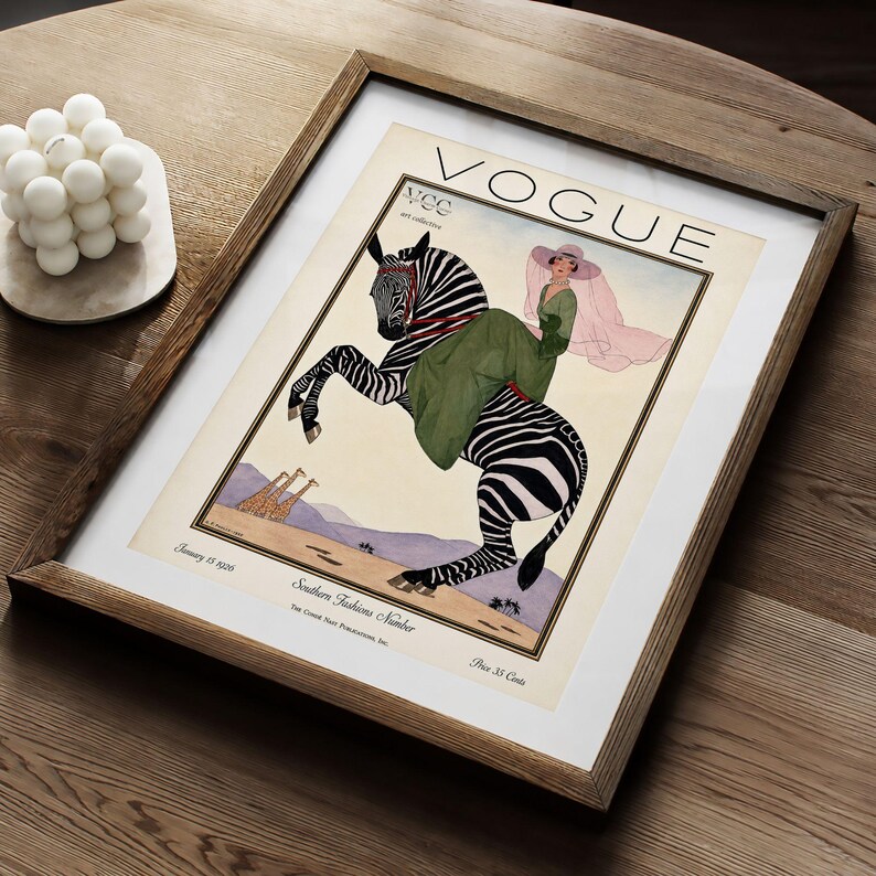 Digitally restored 1926 Vogue magazine cover titled Southern Fashions Number, featuring a stylish woman in a flowing green dress and pink hat riding a zebra in a desert landscape with giraffes and mountains. Vintage Art Deco fashion illustration digital download ideal for gallery walls, eclectic decor, and gifts for fashion history and vintage art lovers.