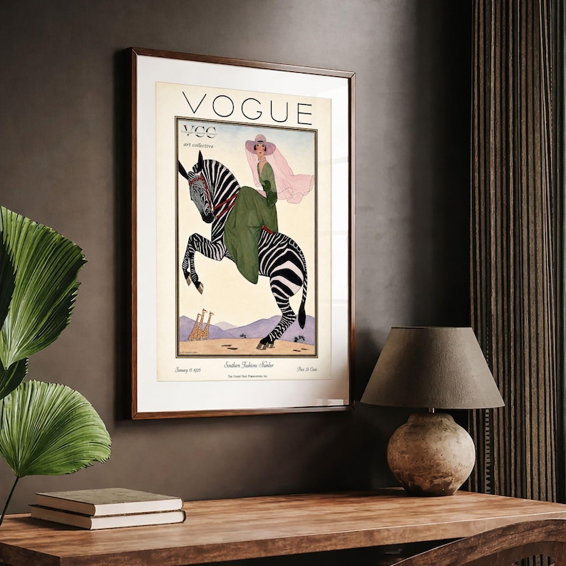 Digitally restored 1926 Vogue magazine cover titled Southern Fashions Number, featuring a stylish woman in a flowing green dress and pink hat riding a zebra in a desert landscape with giraffes and mountains. Vintage Art Deco fashion illustration digital download ideal for gallery walls, eclectic decor, and gifts for fashion history and vintage art lovers.
