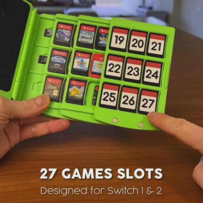 Op de afbeelding: Een lichtgroene game cartridgehouder met sleuven voor 27 games, ontworpen voor Switch 1 & 2. De houder heeft een kalenderachtig ontwerp met genummerde sleuven. Sommige game cartridges zijn zichtbaar.