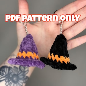 May include: Two crocheted witch hat keychains, one purple with orange trim and one black with orange trim. The text "PDF PATTERN ONLY" is displayed in orange and white.
