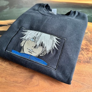 Anime-inspired embroidered pullover sweater with glowing eye!