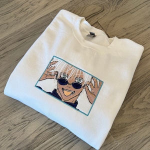 Anime-inspired embroidered pullover sweater with glowing eye!
