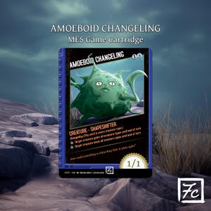 May include: Amoeboid Changeling MES game cartridge. The card features a green, blob-like creature with a face. Text includes "Creature - Shapeshifter" and game instructions. The card has a blue border and the text "Amoeboid Changeling".
