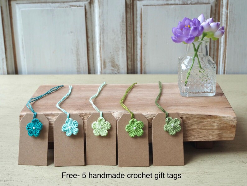 May include: Five handmade crochet gift tags with green and blue flowers. The tags are attached to brown card stock with twine. Free - 5 handmade crochet gift tags.
