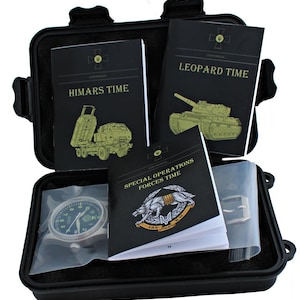 May include: A black case containing a watch and several black user manuals. The manuals are titled "HIMARS TIME", "LEOPARD TIME", and "SPECIAL OPERATIONS FORCES TIME". The watch has a dark face and a silver strap.