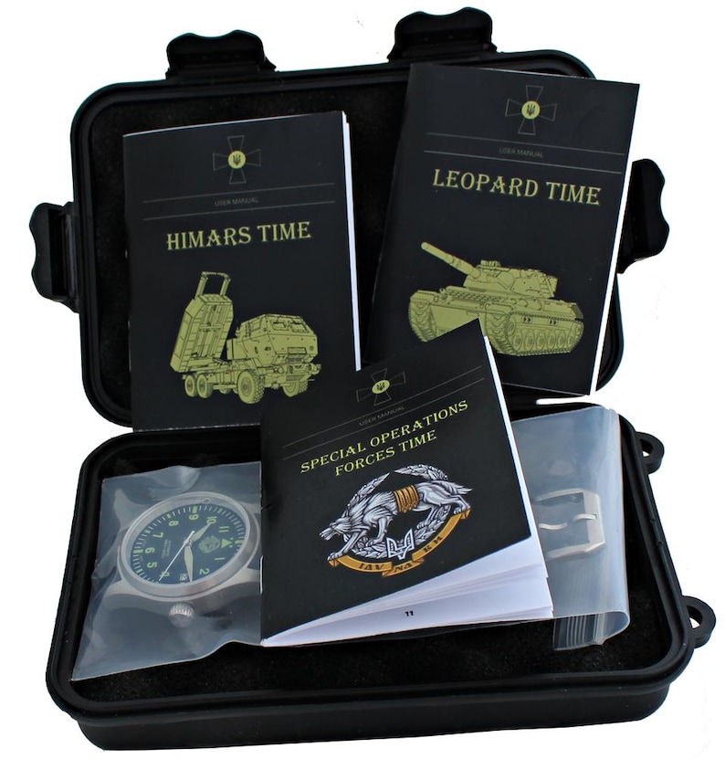 May include: A black case containing a watch and several black user manuals. The manuals are titled "HIMARS TIME", "LEOPARD TIME", and "SPECIAL OPERATIONS FORCES TIME". The watch has a dark face and a silver strap.