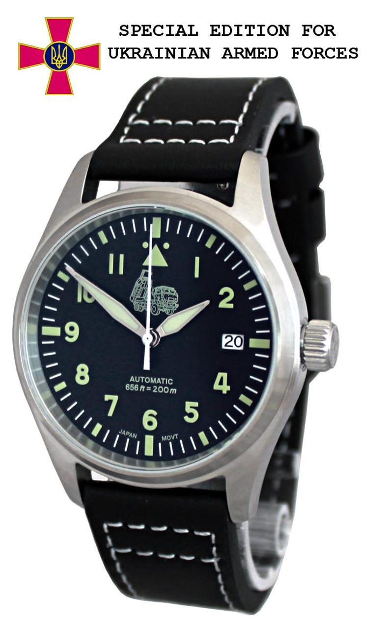 Puede incluir: Un reloj de pulsera negro y plateado con una correa de cuero negro. La esfera del reloj tiene un fondo negro con marcas blancas y una peque&ntilde;a imagen de un cami&oacute;n. El reloj est&aacute; etiquetado como "Automatic 656 ft = 200m" y "Japan Movt". La correa del reloj tiene costuras blancas. El reloj est&aacute; etiquetado como "Edici&oacute;n especial para las fuerzas armadas ucranianas".