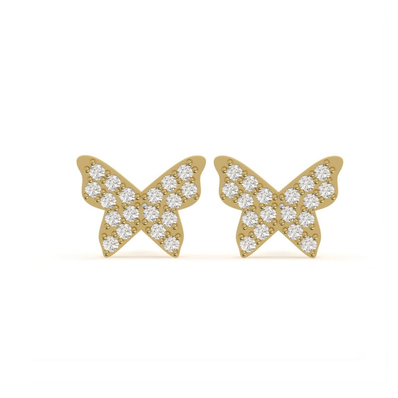 May include: A pair of gold-colored butterfly stud earrings. Each earring features a butterfly shape, with the wings filled with small, sparkling white gemstones. The earrings are set against a white background.