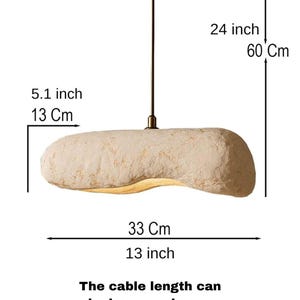 K&ouml;nnte beinhalten: Beige, l&auml;ngliche Pendelleuchte. Die Leuchte ist 33 cm lang, 13 cm breit und das Kabel ist 60 cm lang. Der Text auf dem Bild besagt, dass die Kabell&auml;nge auf Anfrage ohne zus&auml;tzliche Kosten verl&auml;ngert werden kann.