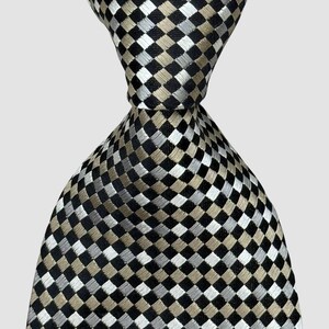 May include: A close-up of a necktie with a checkered pattern. The tie features a repeating design of black, silver, and tan squares. The tie is knotted at the top, showcasing the fabric's texture and design. The background is a solid, neutral color.