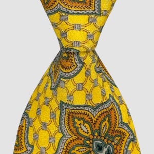 Puede incluir: Una corbata amarilla con un patrón geométrico repetitivo de círculos entrelazados y motivos florales. La corbata presenta un diseño detallado en tonos dorados, verdes y grises. La corbata está anudada, mostrando el intrincado patrón y la paleta de colores.
